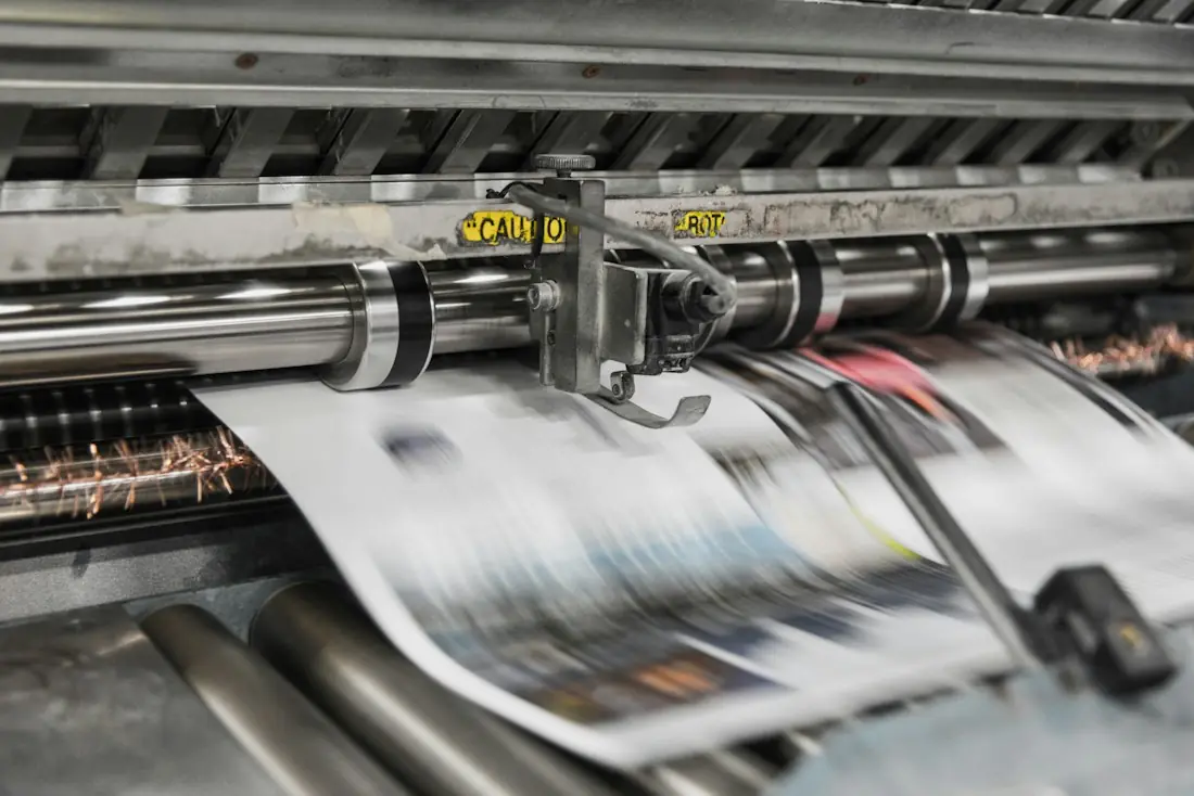 Printing press machine feeding freshly printed paper