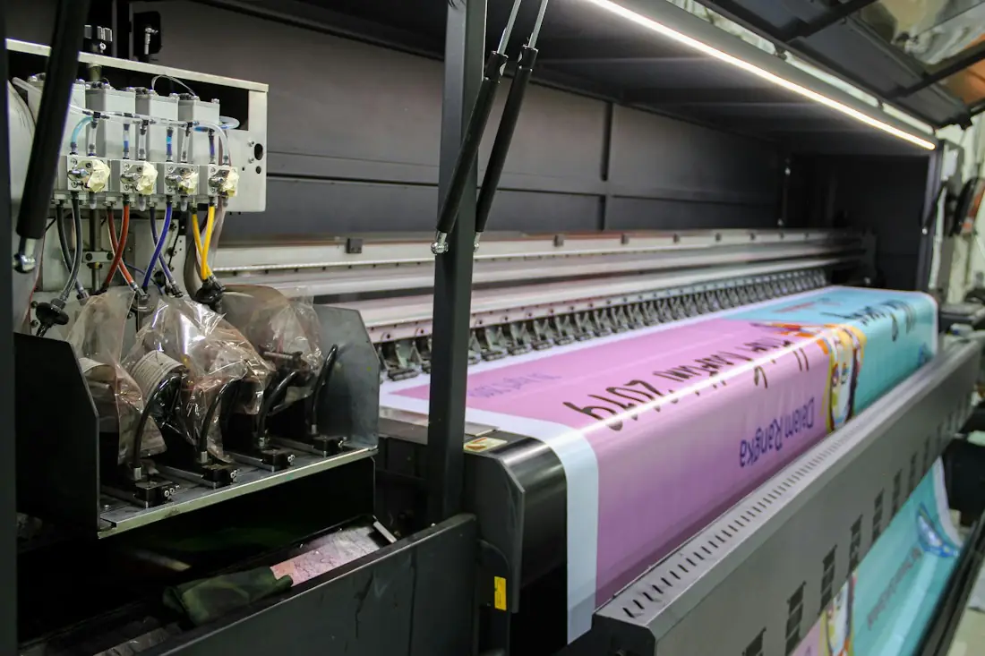 Large-format printer producing a long pink printed banner