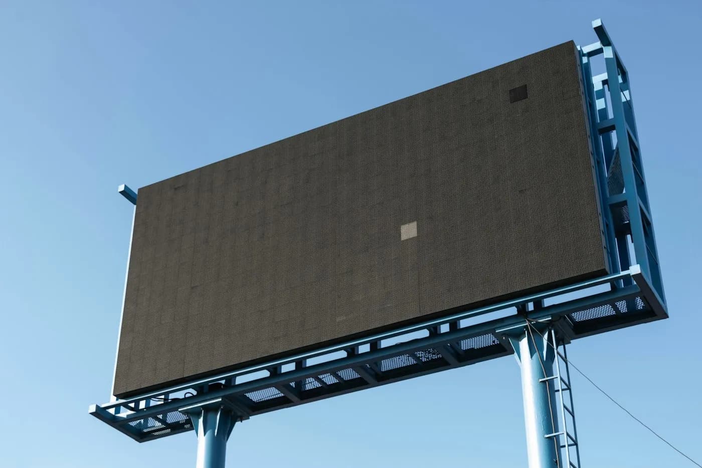 Blank outdoor advertising billboard on a steel frame against a clear blue sky