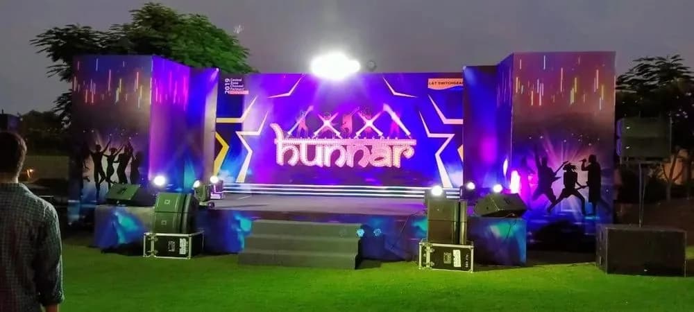 Event stage lit at night with branded backdrop panels, promotional branding by iMad, Jaipur