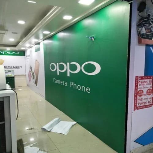 Green branded wall panel inside a mobile phone store, retail branding by iMad, Jaipur