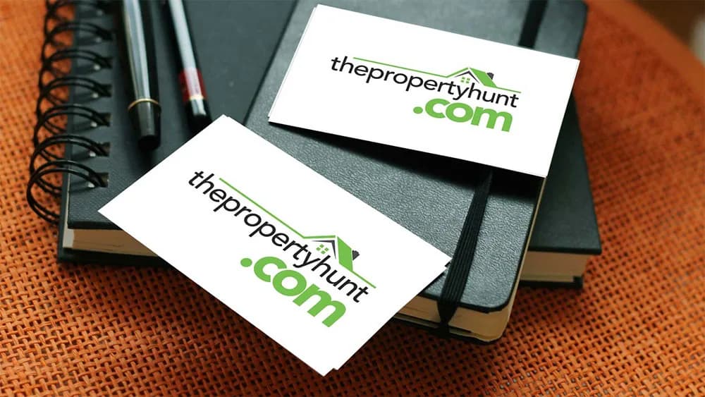 White business cards carrying a green thepropertyhunt.com logo, logo design concept by iMad